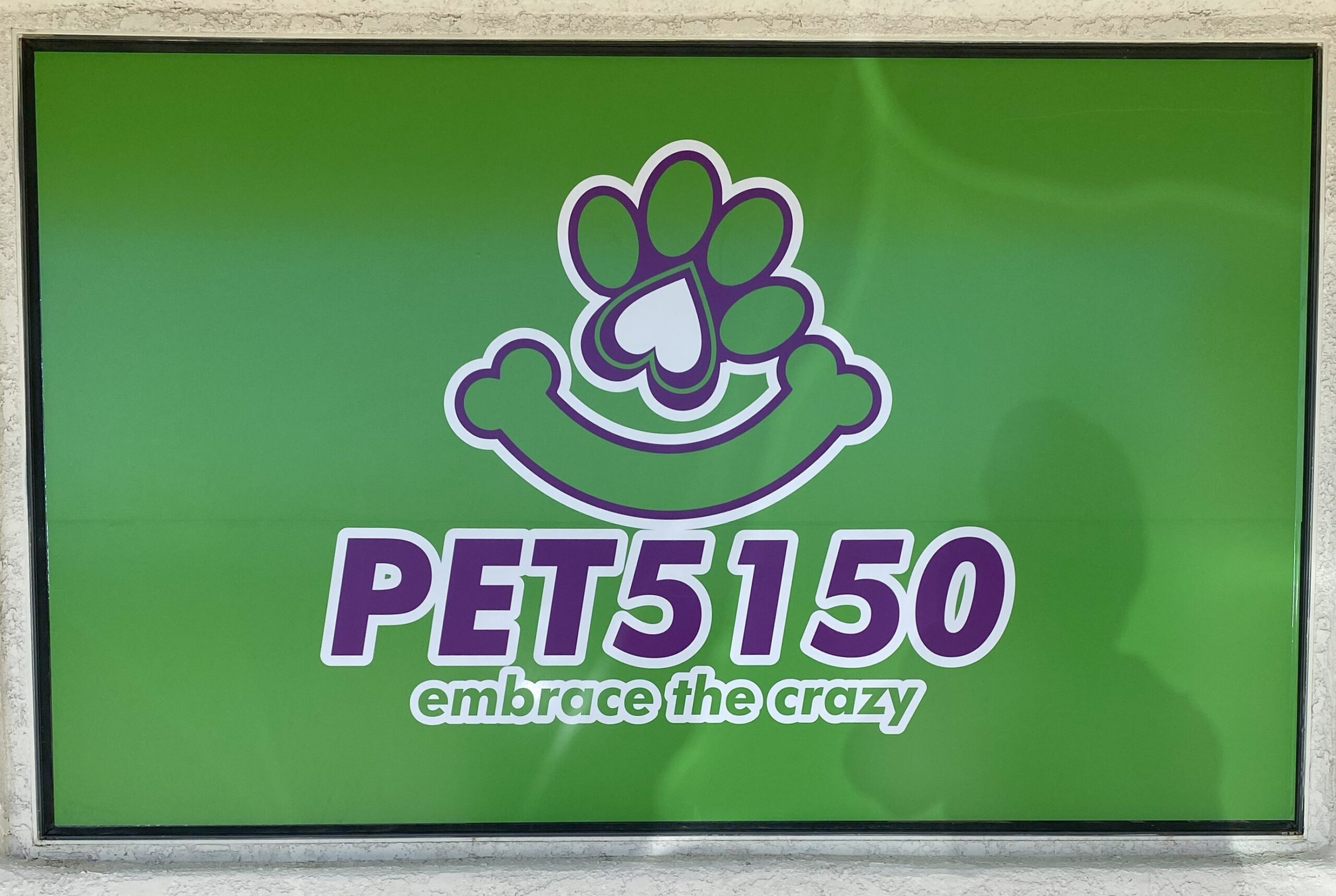 Window sign in Ft. Mohave, AZ that says pets150 embrace the crazy.
